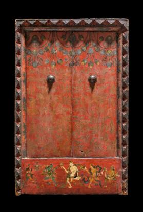 Red wooden cabinet with doors closed. Small depiction of people painted at the bottom